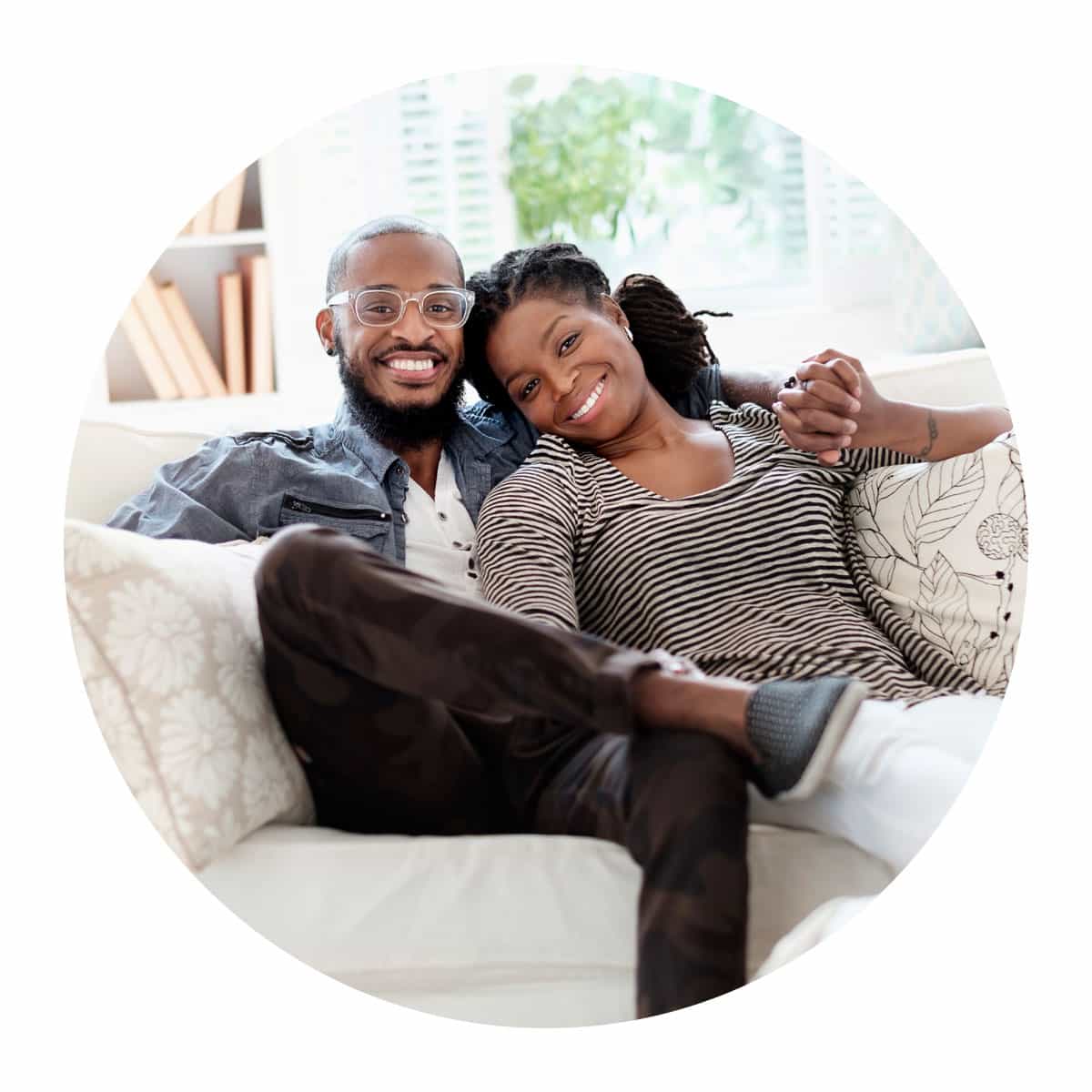 Couple sitting on the couch smiling.