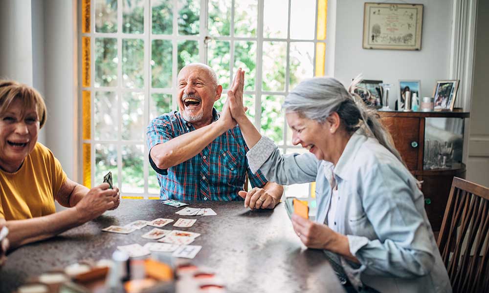 family laughing while sitting around the dinner table