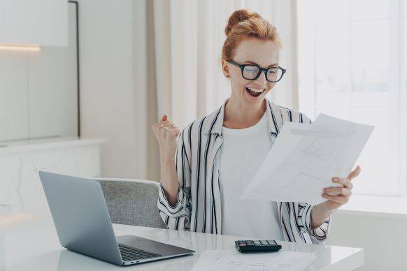 woman at home desk reviewing financial checklist for end of the year