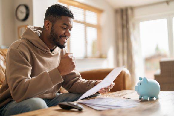 man reviewing tax and financial documents from couch at home