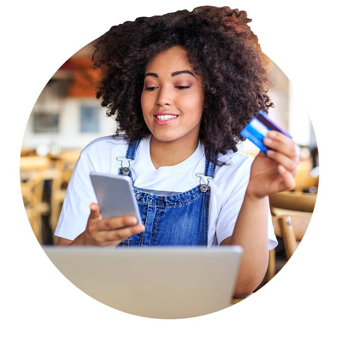 Young woman using her CommunityAmerica Starter Credit Card to make purchases on here phone.