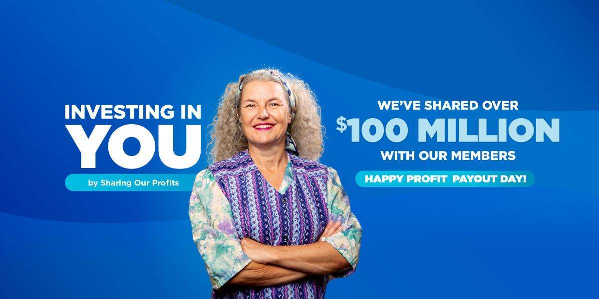 Grey-haired woman standing and smiling with her arms folded for CommunityAmerica Profit Payout Day.